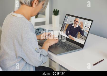 Senior woman talking to her boss online from home office. Doctor and patient online. Stock Photo