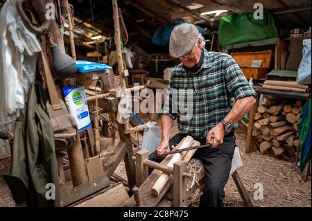 Amberley Museum, Amberley, Sussex, UK, 26th July 2020. After being closed for over 4 months during the Covid-19 crisis, Amberley Museum has opened its doors to families and visitors once again. In Picture: Volunteer craftsperson, Colin Wells, who's also known as the Amberley Bodger, working in his workshop at the museum. Colin is a pole lathe turner and demonstrator and has been volunteering at the museum for 15 years. Credit: Scott Ramsey/Alamy Live News. Stock Photo