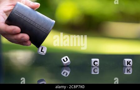 Symbol for having luck. Hand rolls the dice which form the word "luck". Stock Photo