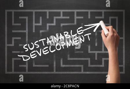 Hand drawing SUSTAINABLE DEVELOPMENT inscription with white chalk on blackboard, new business concept Stock Photo