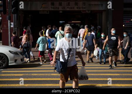 An elderly man walks across the street while wearing a face mask as a preventive measure against the spread of Coronavirus (COVID-19).China’s semi-autonomous region reported 108 coronavirus cases on Sunday followed by a mix of 100 preliminary and confirmed cases today, according to daily South China Morning Post. It was the first time since the outbreak that Hong Kong reported COVID-19 cases in 3-digits. The new cases have pushed the total number to nearly 2,000 in the region. At least 12 people have died due to the virus so far. Stock Photo