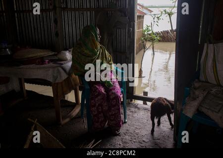 A sick woman sitting in her flood inundated house Stock Photo