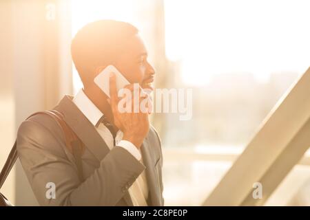 Smiling Black Man Talking On Phone Walking In Airport Indoor Stock Photo