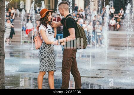 Moscow, Russia - may 1, 2018. Active people in the city. Young man, woman wear skirt and other people enjoing in a city fountain Stock Photo