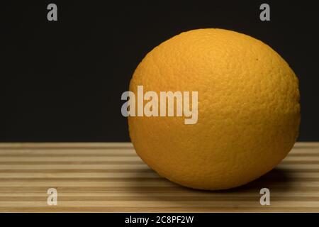 Three fresh orange on circle wood tray with dark Stock Photo
