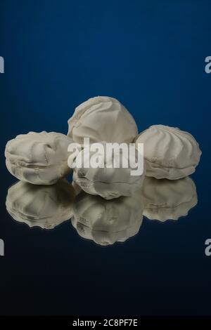 Three white marshmallows on a blue background Stock Photo