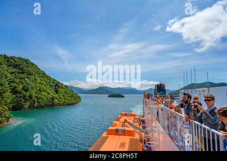 Passengers viewing the Marlborough Sounds from the deck of the Wellington to Picton ferry, South Island, New Zealand Stock Photo