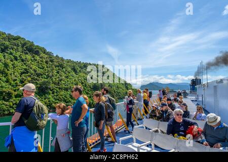 Passengers viewing the Marlborough Sounds from the deck of the Wellington to Picton ferry, South Island, New Zealand Stock Photo
