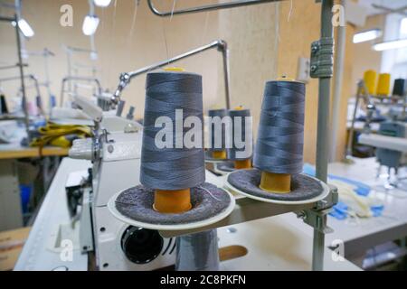 large sewing spools installed on a sewing machine in production Stock Photo
