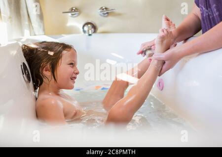 4 year old boy having a bath and shampoo in bath tub