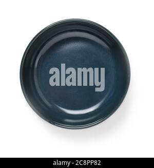 Empty dark blue ceramic bowl or ramekin isolated on a white background. Empty crockery for food design. Clay, ceramics, porcelain tableware. Top view. Stock Photo
