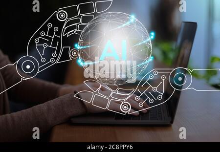 Virtual cyborg hands holding sphere with AI text over workplace Stock Photo