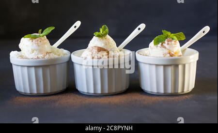 Background of three balls of ice cream in cups. Three servings of ice cream. Fresh ice cream for dessert. Stock Photo