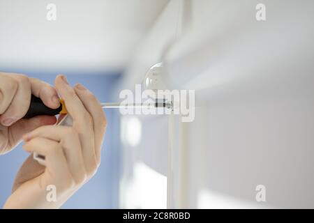 Man installing cassette roller blinds on windows Stock Photo