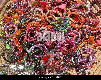 Colorful decorative wooden necklaces displayed outside in the market. Stock Photo