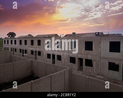 Serial construction of cast concrete homes on site, small family home in Guatemala, dramatic sunset. Stock Photo