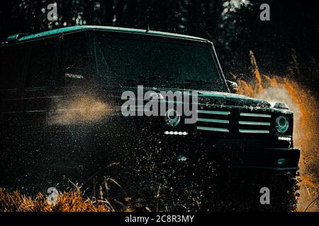 Off-road travel on mountain road. Off road sport truck between mountains landscape. Offroad vehicle coming out of a mud hole hazard. Mudding is off Stock Photo