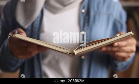 Anonymous woman reading book in library, eduational concept. Happy smiling expression when doing leisure activity Stock Photo