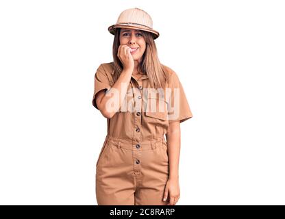 Young beautiful woman wearing explorer hat looking stressed and nervous with hands on mouth biting nails. anxiety problem. Stock Photo