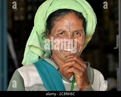 Elderly Chin Muun tribal woman ('spider woman') with traditional facial tattoo poses for the camera. Stock Photo