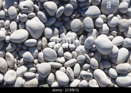 Close up of bright white and grey stones at a sunny beach Stock Photo