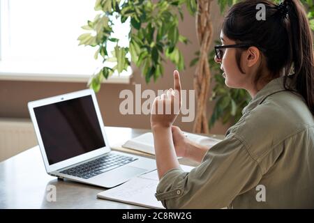 Over shoulder view of indian female teacher giving online class by video call. Stock Photo