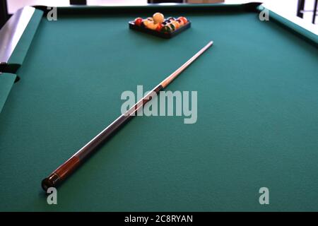 Pool cue on a green felt pool table Stock Photo