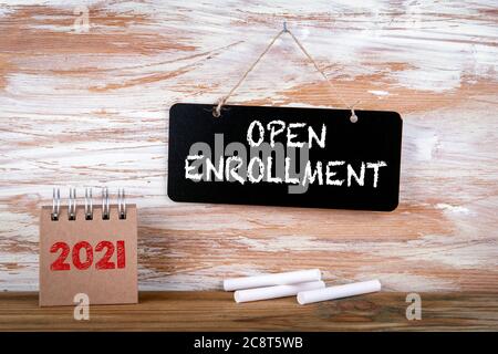 OPEN ENROLLMENT. Small chalk board and white chalk on a wooden background Stock Photo