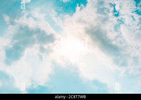 sun behind clouds in blue sky in summer day Stock Photo