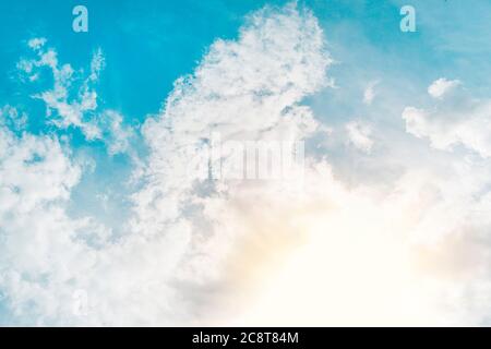 ecrice the rays of the sun shining through the feathery white clouds in the blue sky. Beautiful background. sky with clouds and sun Stock Photo