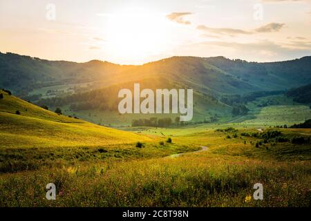 Sunny morning in mountain. Sunset over the mountains. Summer landscape in the mountains. Serpentine mountain road. Beautiful landscape composition. Stock Photo