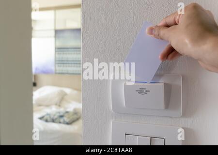 Hand insert key card in the luxury hotel room. Stock Photo
