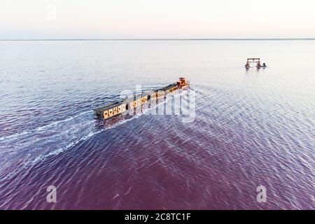 train travels from water. Mined salt in Lake Burlin. Altai. Russia. Bursolith. Old train rides on the railway laid in the water through the salt lake Stock Photo