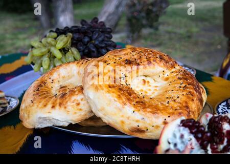 Naan bread on a wooden table. Top view. Fresh fragrant crispy bread. Tandoor bread on cutting board closeup. Home-made bread on an old background Stock Photo