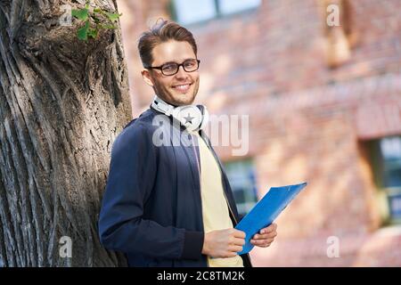 Male student in the campus studying outdoors Stock Photo