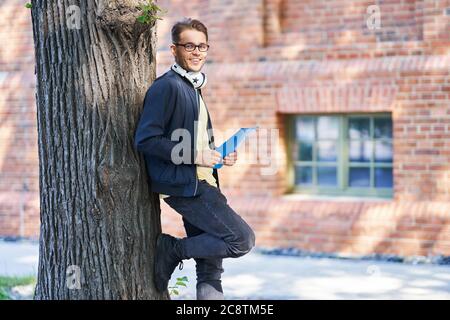 Male student in the campus studying outdoors Stock Photo