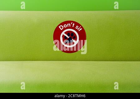 A green padding seating area with a Don't Sit sign, as part of the safety social distancing measures put in place to combat the global Covid 19 pandem Stock Photo