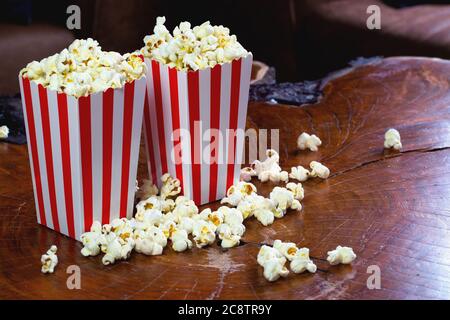 Popcorn in striped retro red and white cardboard box for cinema on wooden table Stock Photo
