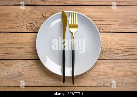 empty round gray plate, fork, knife on wooden table Top view Flat lay Dishes for breakfast, lunch or dinner Mock up Copy space Rustic vintage Stock Photo