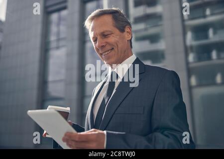 Cheerful man using tablet computer on the street Stock Photo