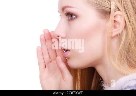 Gestures and signs concept. Young blonde woman whispering to somebody having open hand next to mouth. Stock Photo