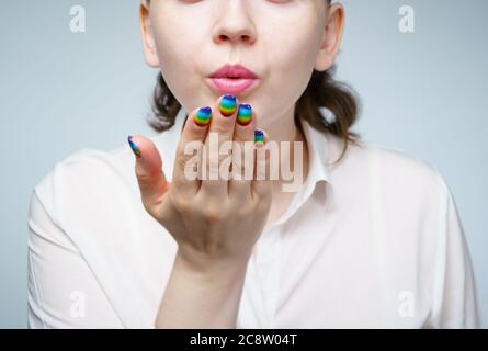 Photo of woman with rainbow manicure doing air kiss Stock Photo