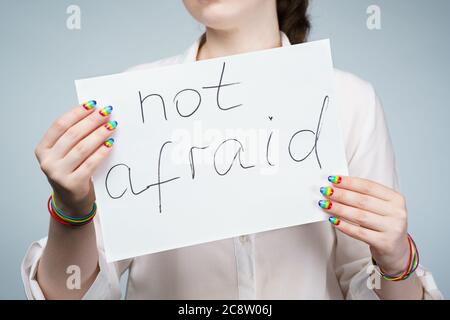 Image of girl with rainbow nails holding poster Stock Photo