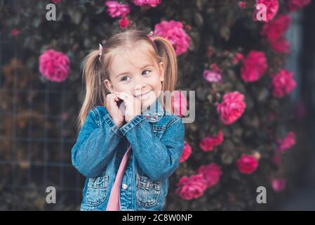 Stylish kid girl 1-2 year old wearing dress and jacket over city