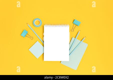 Notepad template with mint stationery on a bright yellow background. Creative mockup with copy space. Stock Photo