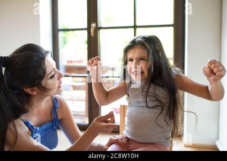 Portrait of mother and angry small girl indoors, tantrum concept. Stock Photo