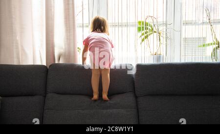 Little baby girl on the sofa at home. copy space