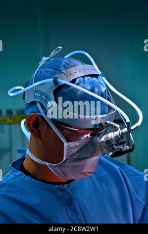 Surgeon Operating Using A Fibre-optic Head-light To Enable A Clear View 