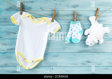 Baby clothes and white bear toy on a clothesline Stock Photo