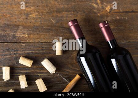 Glass bottle of wine with corks on wooden table background. Top view. Stock Photo